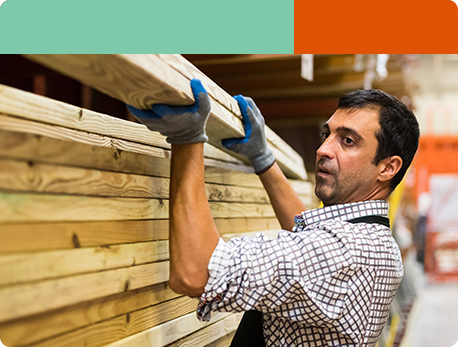 A carpenter handling a big piece of timber